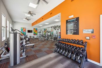 A gym with orange walls and a variety of equipment